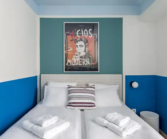 a bed with white sheets and towels on it