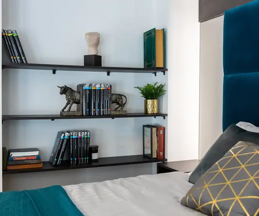 a bed with books on shelves
