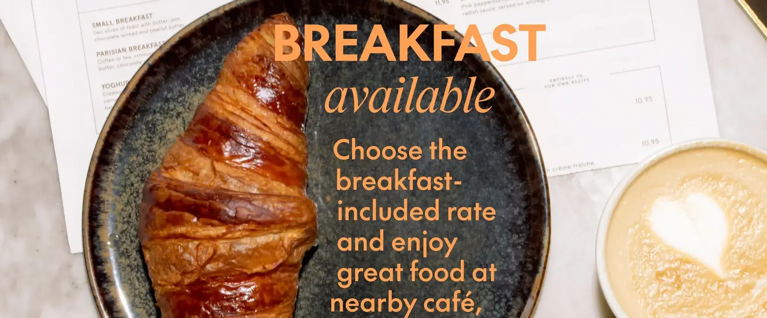 a croissant on a plate next to a phone and a cup of coffee