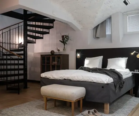 a bedroom with a spiral staircase and a bed