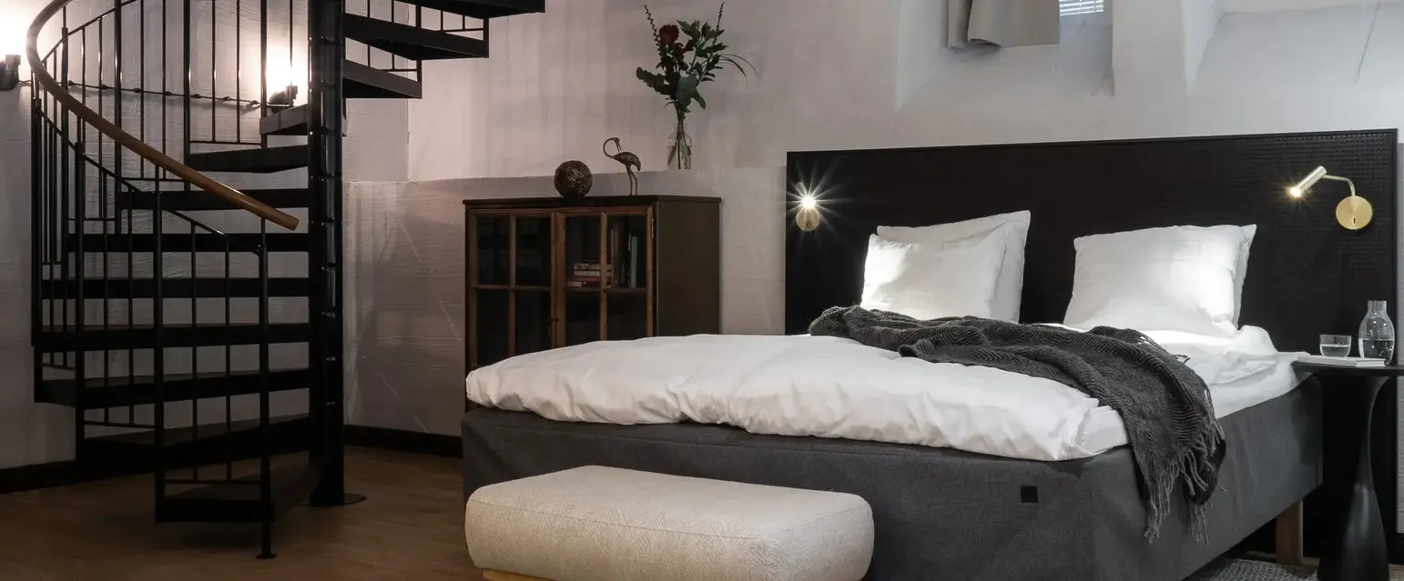 a bedroom with a spiral staircase and a bed