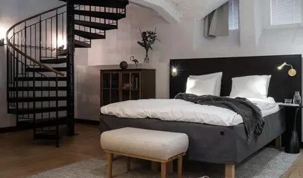 a bedroom with a spiral staircase and a bed
