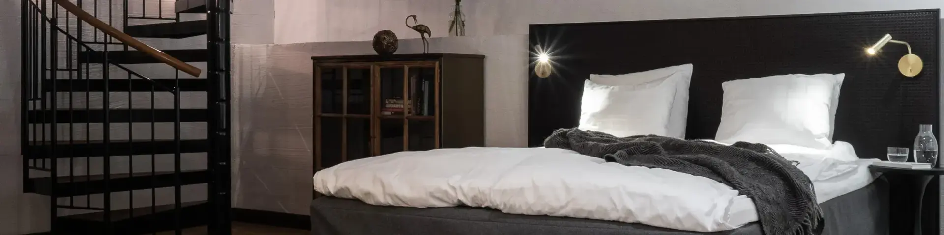 a bedroom with a spiral staircase and a bed