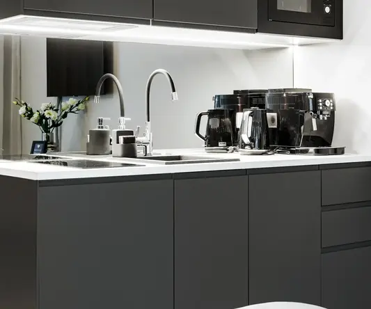 a kitchen with black cabinets and appliances