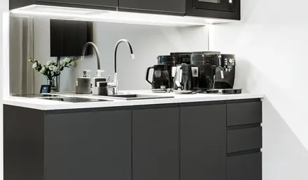 a kitchen with black cabinets and appliances