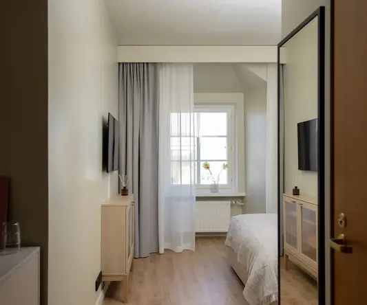 a bedroom with a tv and a window