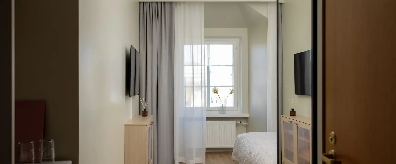 a bedroom with a tv and a window