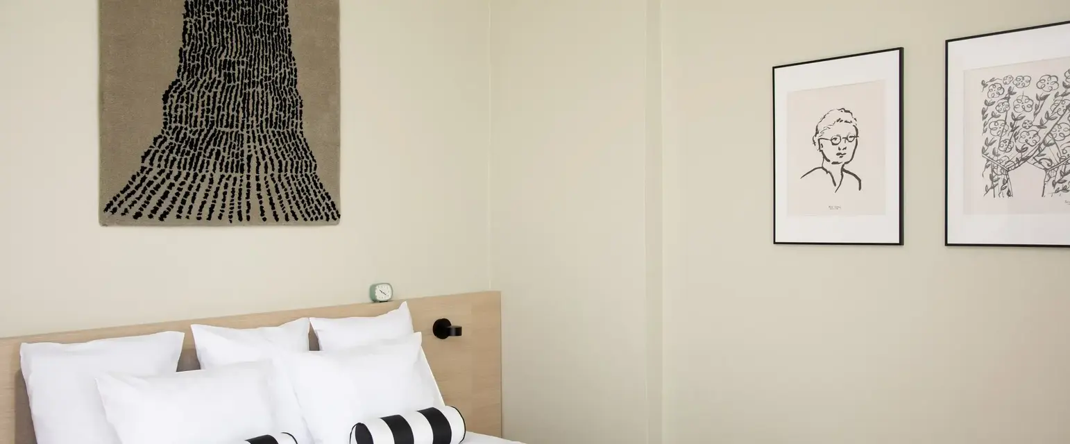 a bed with pillows and a picture on the wall