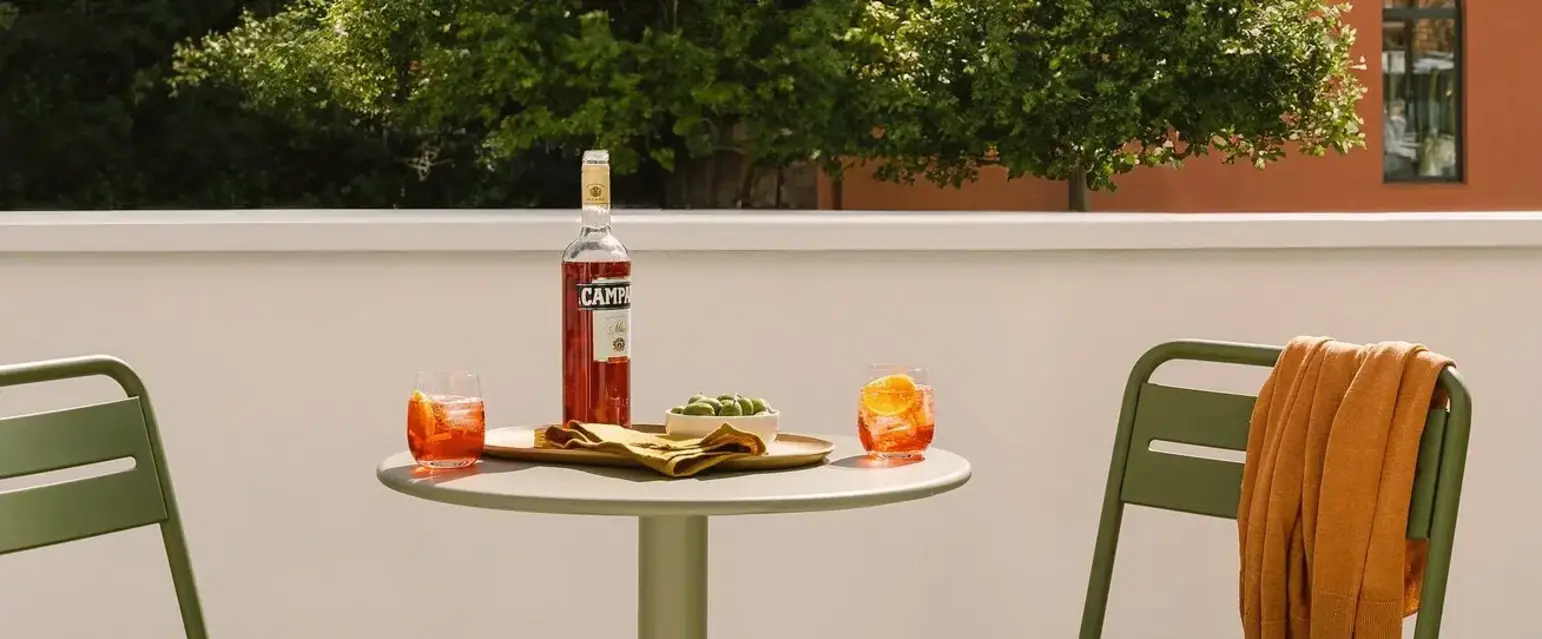 a table with two chairs and a bottle of alcohol on it