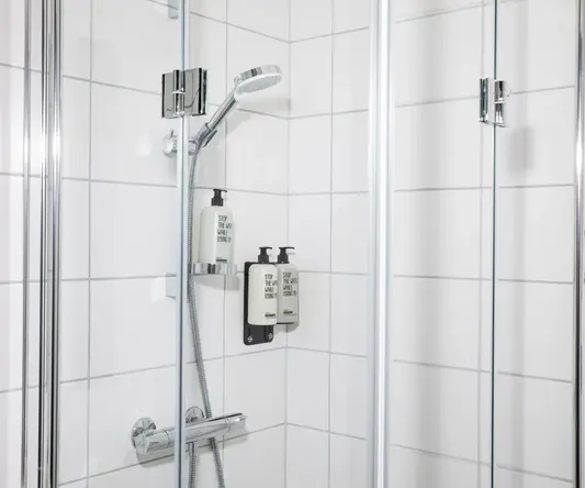 a shower with a shower head and soap dispensers
