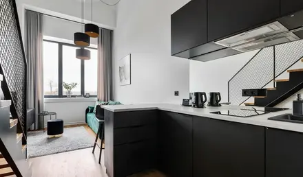 a kitchen with black cabinets and a green couch