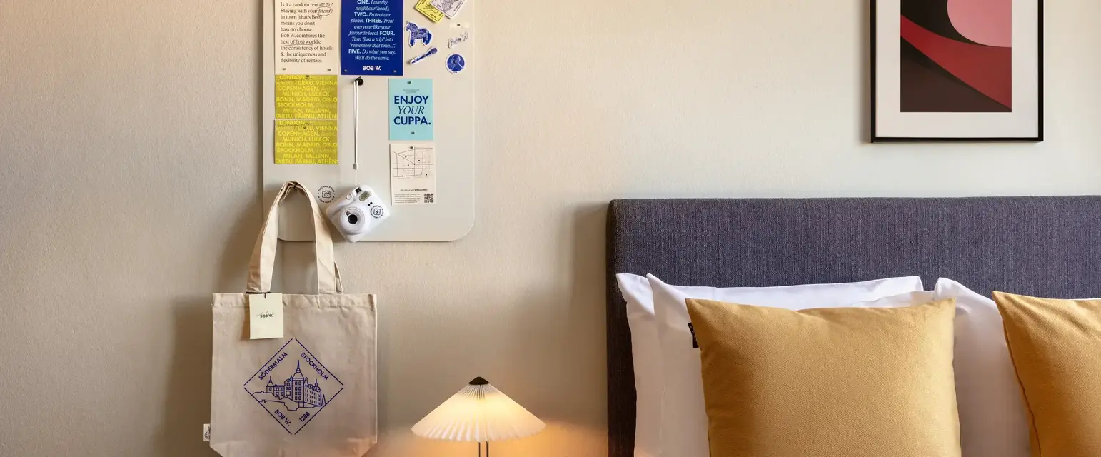 a bed with pillows and a lamp on a table