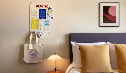 a bed with pillows and a lamp on a table