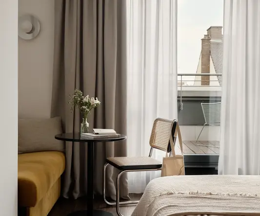 a room with a table and chairs and a bed and a balcony