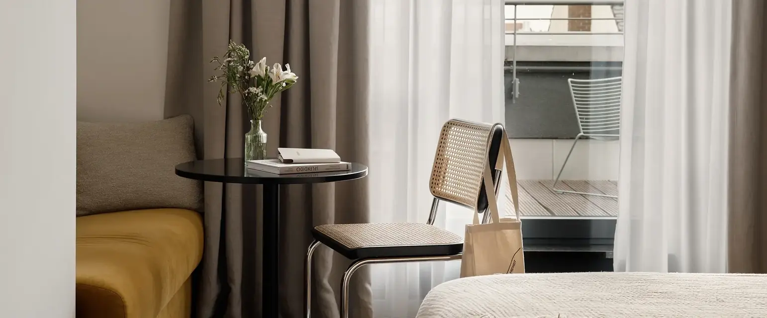 a room with a table and chairs and a bed and a balcony