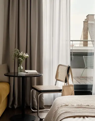 a room with a table and chairs and a bed and a balcony