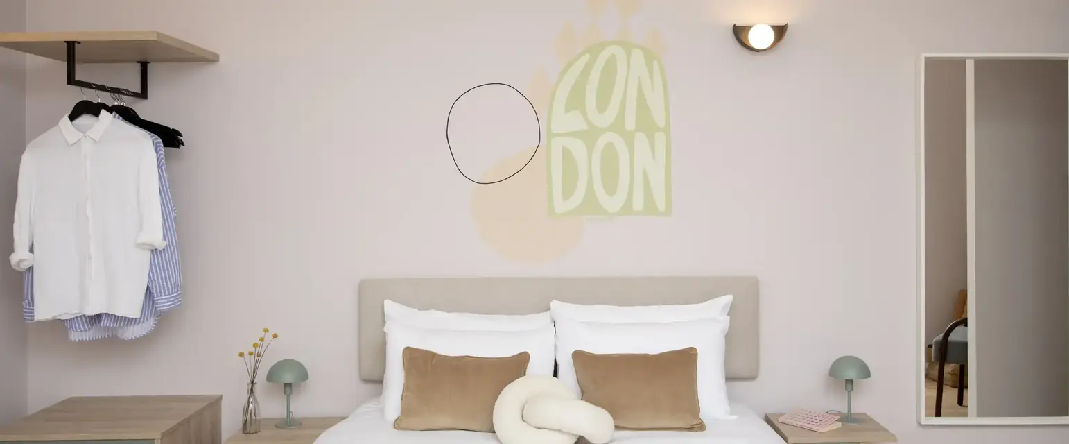 a bed with pillows and a lamp on the wall