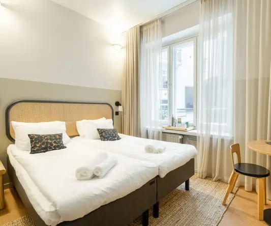 a bedroom with a table and two beds