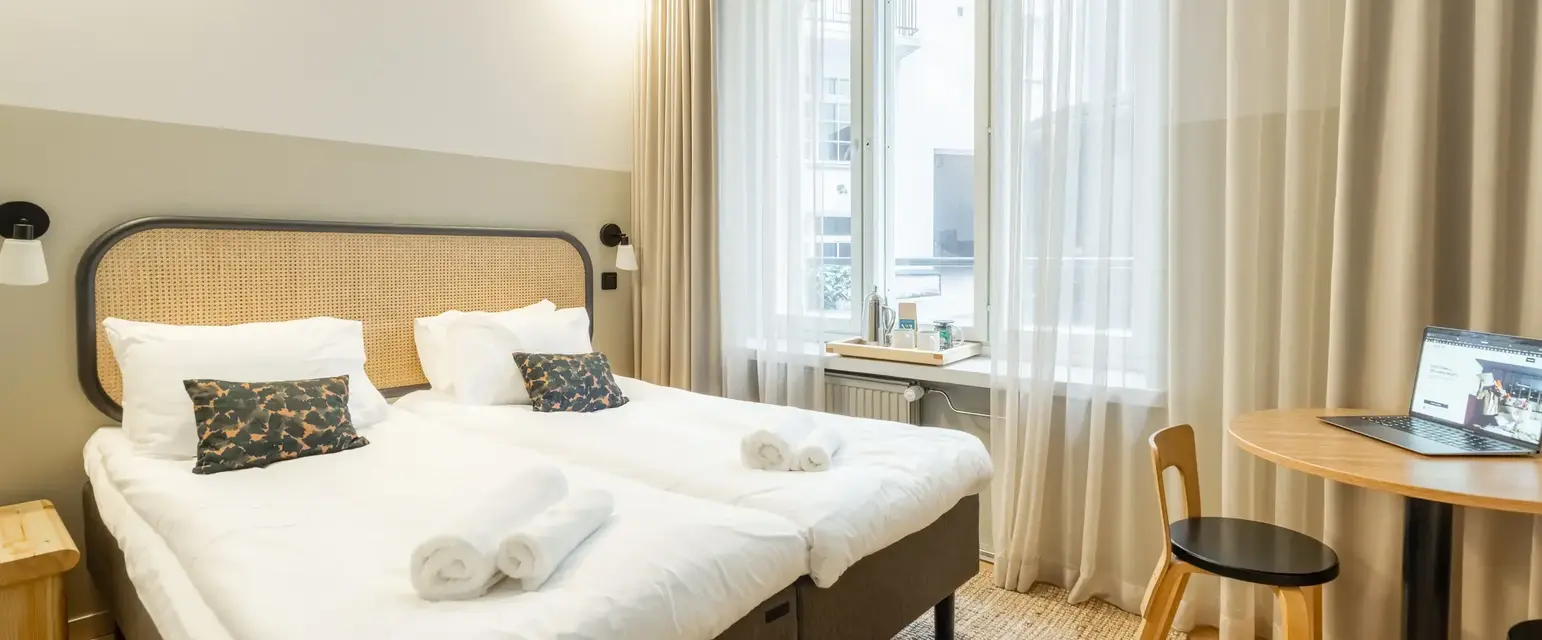 a bedroom with a table and two beds