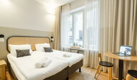 a bedroom with a table and two beds