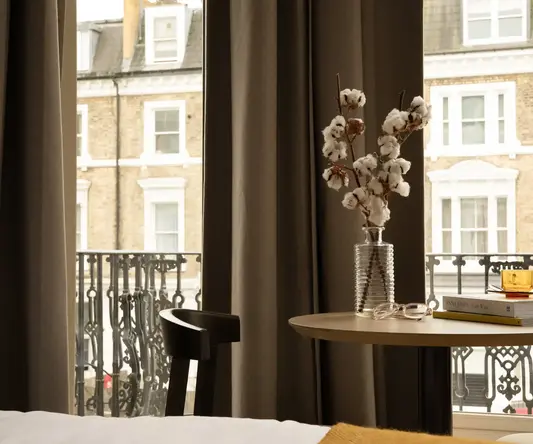 a vase with cotton flowers on a table