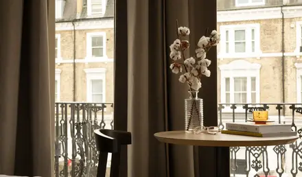 a vase with cotton flowers on a table
