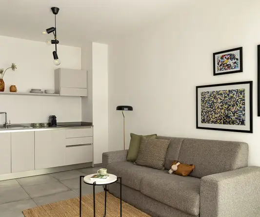 a living room with a couch and kitchen