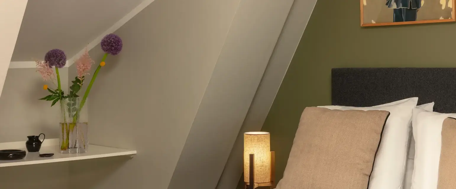 a bed with a lamp and a picture on the wall