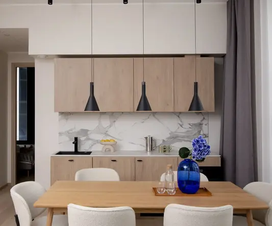 a dining table with chairs and a blue vase on it
