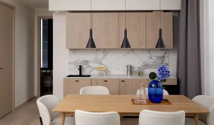 a dining table with chairs and a blue vase on it