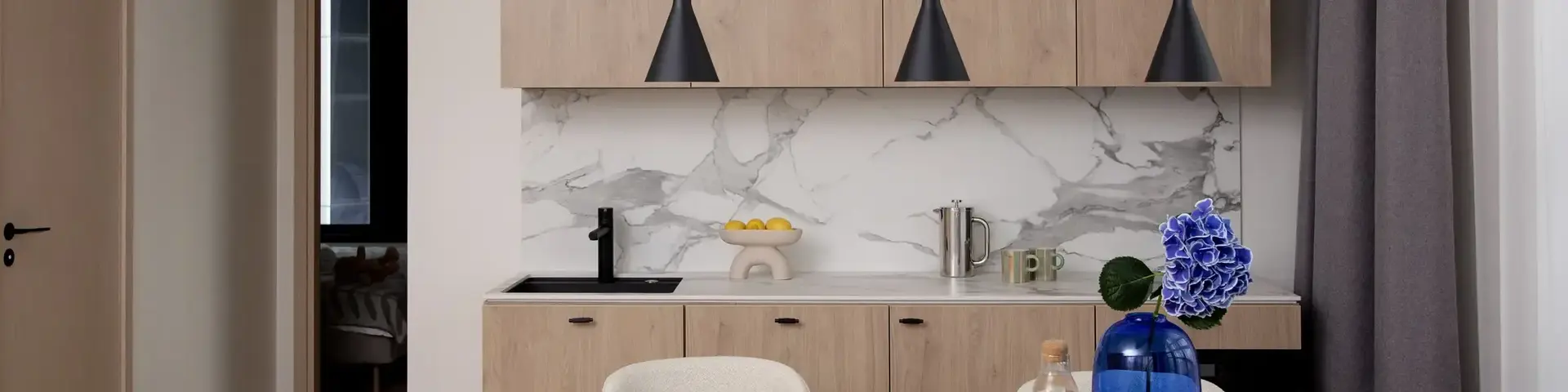 a dining table with chairs and a blue vase on it
