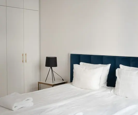a bed with white sheets and pillows