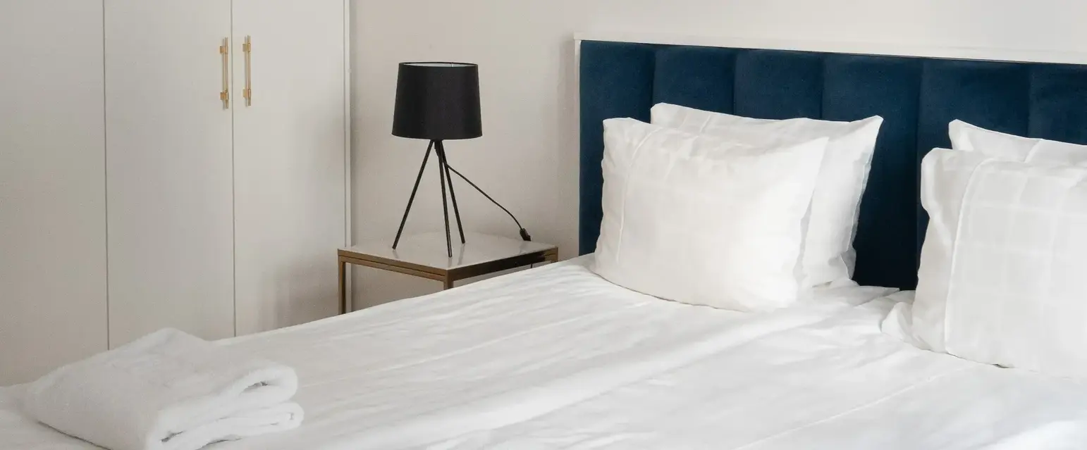 a bed with white sheets and pillows