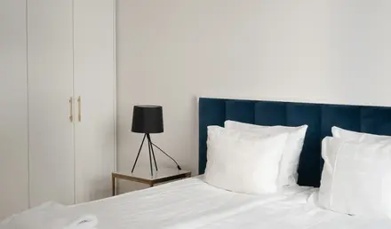 a bed with white sheets and pillows