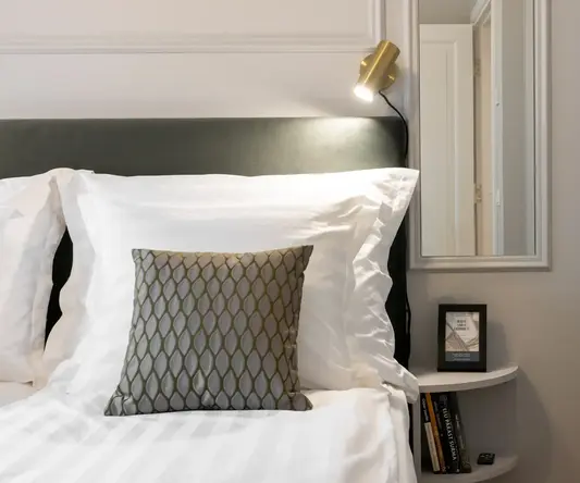 a bed with a mirror and a lamp