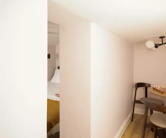 a room with a bed and chairs