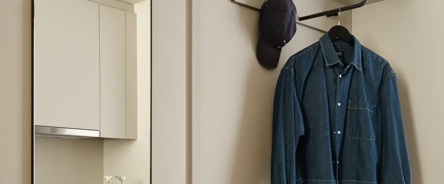 a room with a coat rack and a mirror