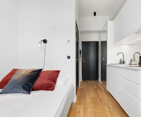 a bedroom with a black door and a wood floor