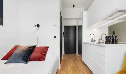 a bedroom with a black door and a wood floor