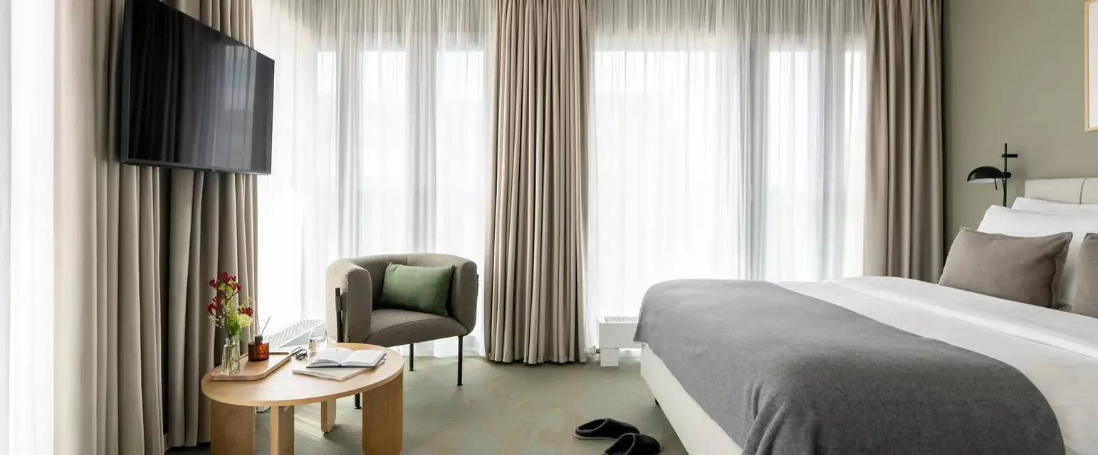 a room with a bed and a chair and a television