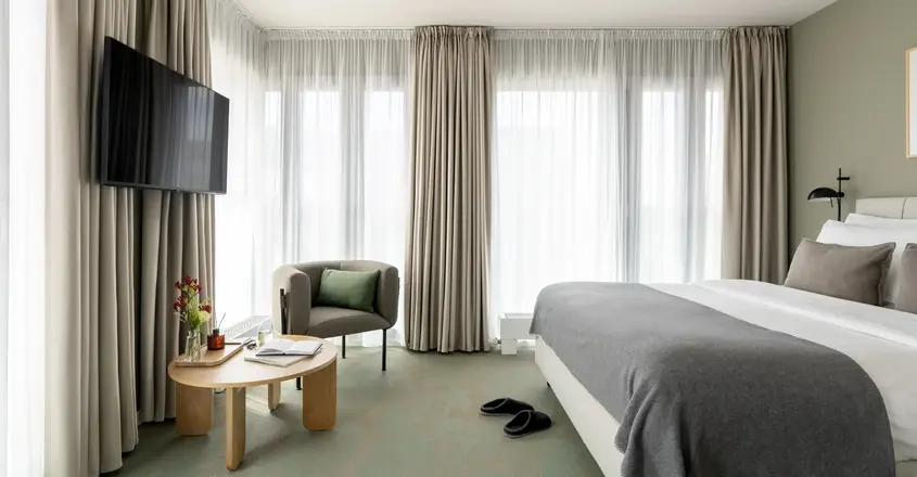 a room with a bed and a chair and a television