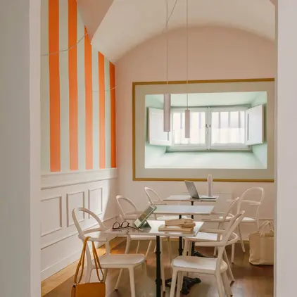 a room with white chairs and tables