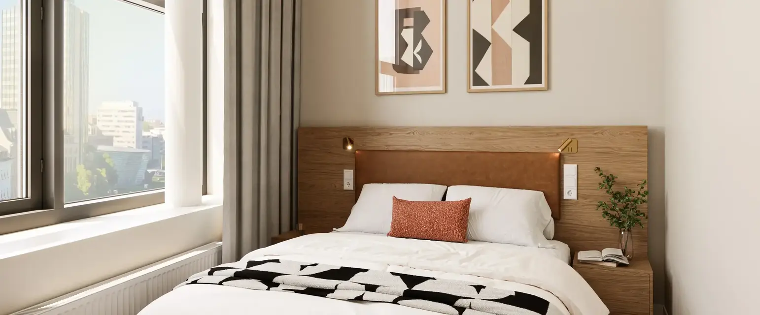 a bed with a wood headboard and a lamp