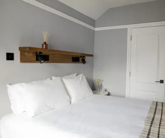 a bed with white sheets and pillows