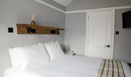 a bed with white sheets and pillows