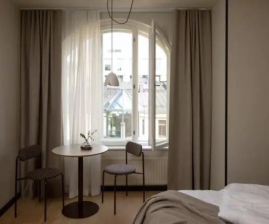 a room with a bed and chairs and a table