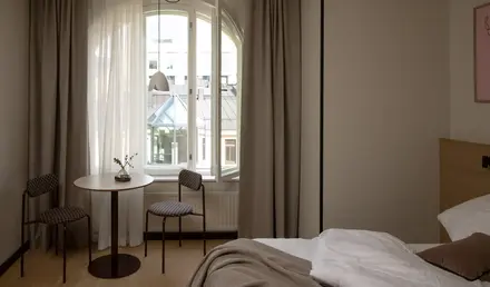 a room with a bed and chairs and a table