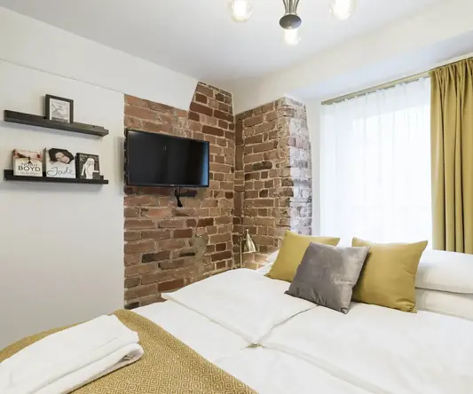 a bed with a tv on the wall