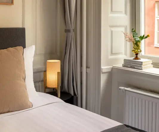 a bed with a lamp next to a window