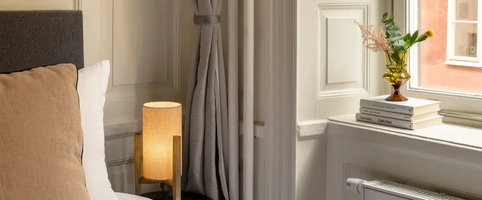 a bed with a lamp next to a window